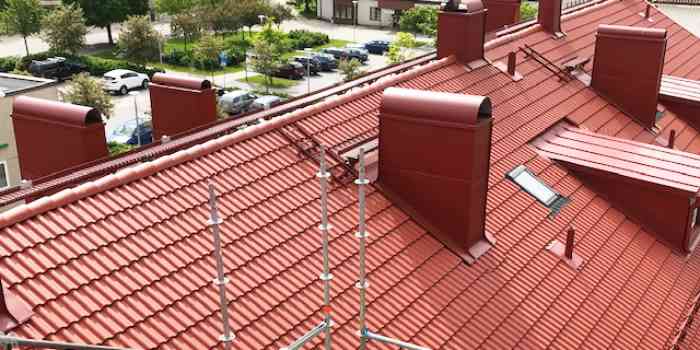 Rött tegeltak med flera skorstenar och ventilationsutgångar