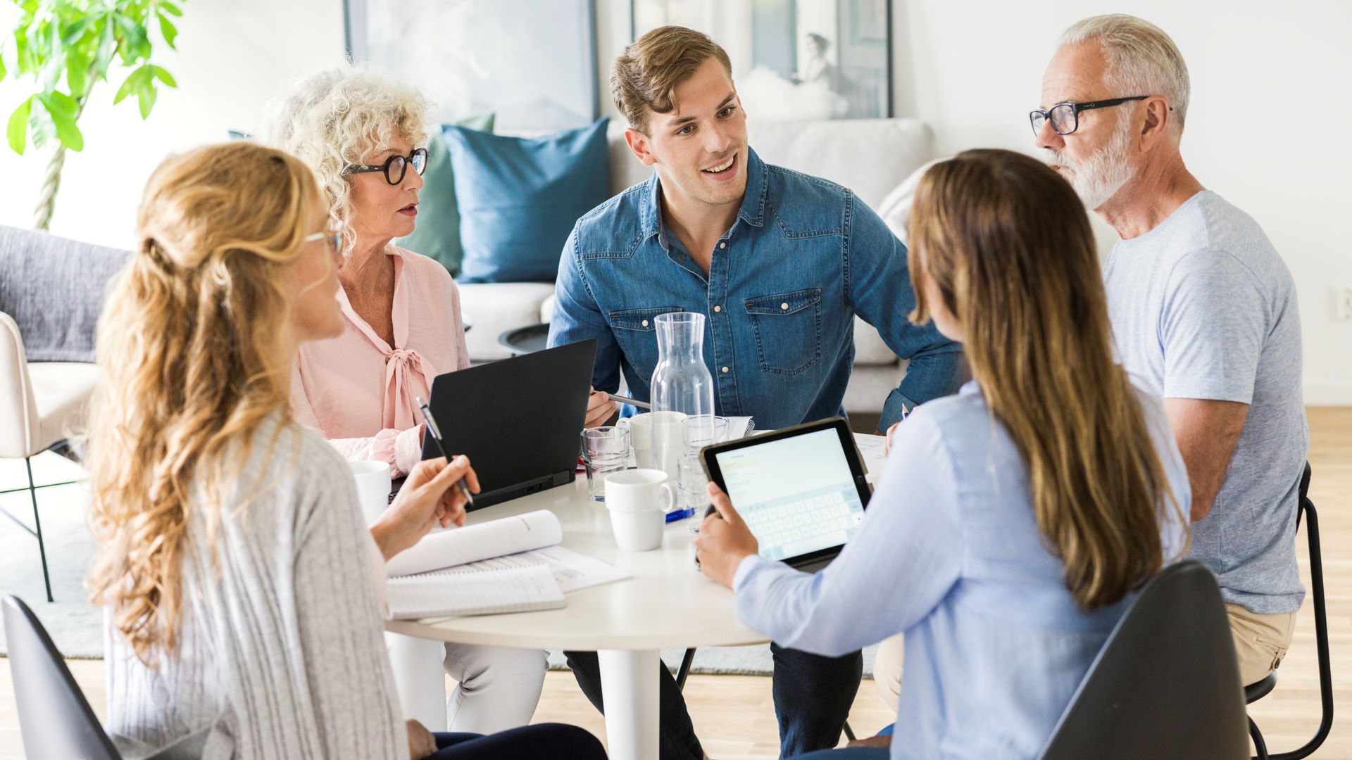 M&auml;nniskor runt ett bord med laptops