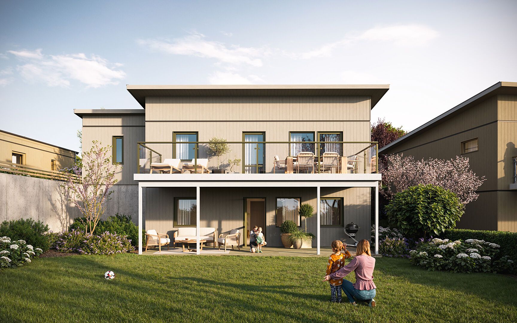 Modern villa i två våningar med stor terrass och trädgård, familj leker på gräsmattan framför huset