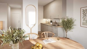 Modern köksdesign med ljusa färger, träbord med blommig dekoration och citroner, en öppen bok, och en väggspegel mot en minimalistisk bakgrund